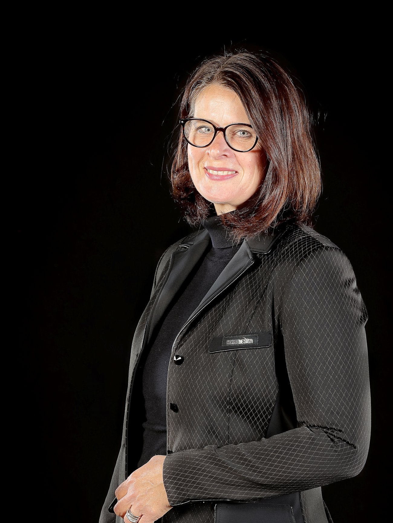 Porträt von Katja Stöver vor schwarzem Hintergrund.