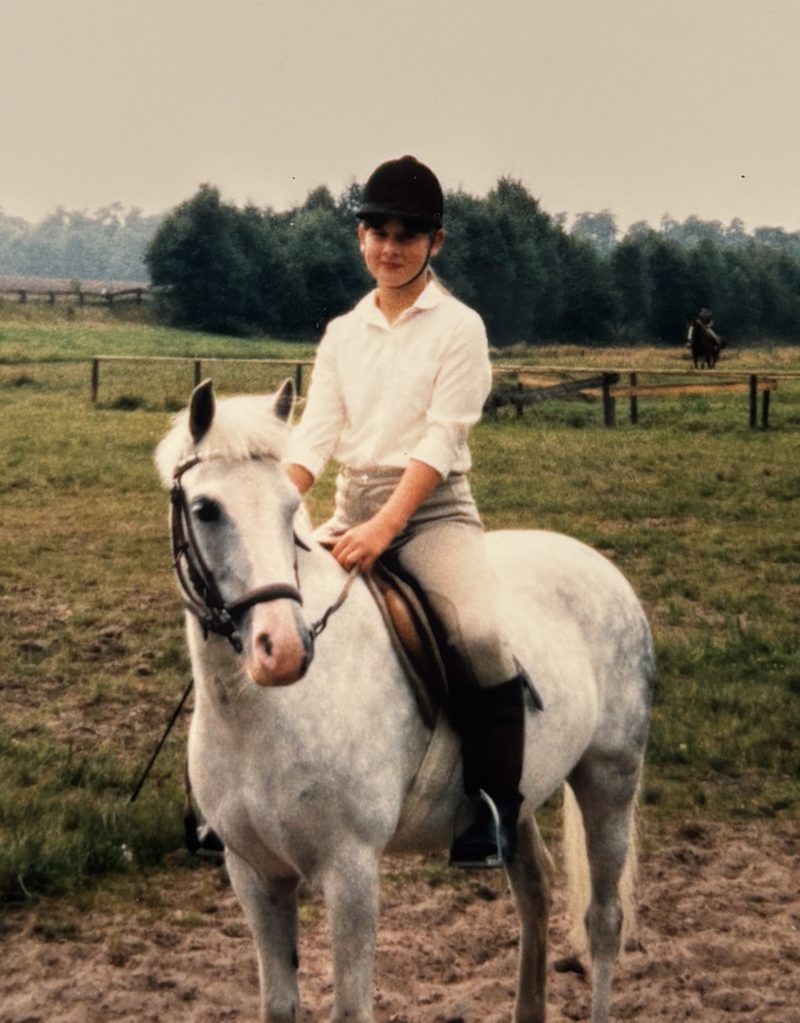 Katja Stöver als Kind auf ihrem ersten Pony, einer Schimmelstute.